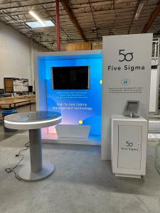 RENTAL: RE-1081 Design with White Laminated Framed Lightbox, Canopy Structure, Small White Laminated Workstation Counter, Planter Box, Storage Box, RE-704 Charging Station Table, Monitor Mount, RE-1243 iPad Counter Stand, SEG Fabric Graphics, and Vinyl Ap