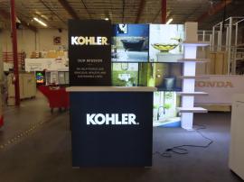 Custom Inline Exhibit with Fabric and Tension Fabric Graphics, Backlit Dimensional Logo, LED Lightbox, Waterfall Shelving Unit, and MOD-1726 Backlit Counter with Locking Storage