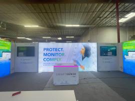 RENTAL: Modified RE-2125 Inline Design with (1) 192" Wide x 95" High Single-Sided Lightbox, (2) 76" Wide x 95" High Single-Sided Lightbox, (2) 36" Wide x 95" High Double-Sided Return Lightboxes, (2) Large Monitor Mounts, (2) 65" Monitors, RE-1576 Receptio