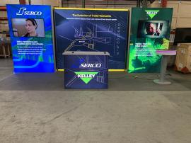 RENTAL: RE-2138 Inline Design with (1) 110" W x 96" H Single-Sided Lightbox, (2) 60" W x 96" H Single-Sided Lightboxes, (2) 12" W x 96" H Return Panels, (2) Large Monitor Mounts, (2) 50" Monitors, RE-711 Charging Station Table, RE-1567 Backlit Reception C