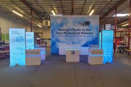 Custom Peninsula Island with 16 ft. Backwall with SEG Graphic, (4) Product Display Stands with Acrylic Tops and RGB LED Lighting, (4) Double-sided SuperNova Lightboxes with Monitor Mounts, (3) MOD-1596 Counters with Locking Storage and RGB Accent Lights,