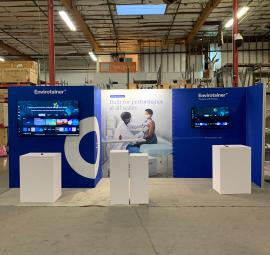 RENTAL: RE-2168 Gravitee Panel System Inline Design with Storage Closet with Locking Door, (2) LED Arm Lights, (2) Large Monitor Mounts, (1) 65" Monitor, (1) 43" Monitor, (1) 20" x 26" x 36" High White Laminated Product Pedestal, (1) 20" x 26&rdquo; x 39" Hig