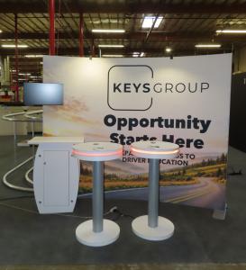 Symphony Portable Modular Curved Frame, SEG Tension Fabric Graphic, SYM-408B Portable Counter with Locking Storage, Monitor Mount, LED Stem Lights, and (2) MOD-1462 Wireless Charging Tables with LED Accent Lights